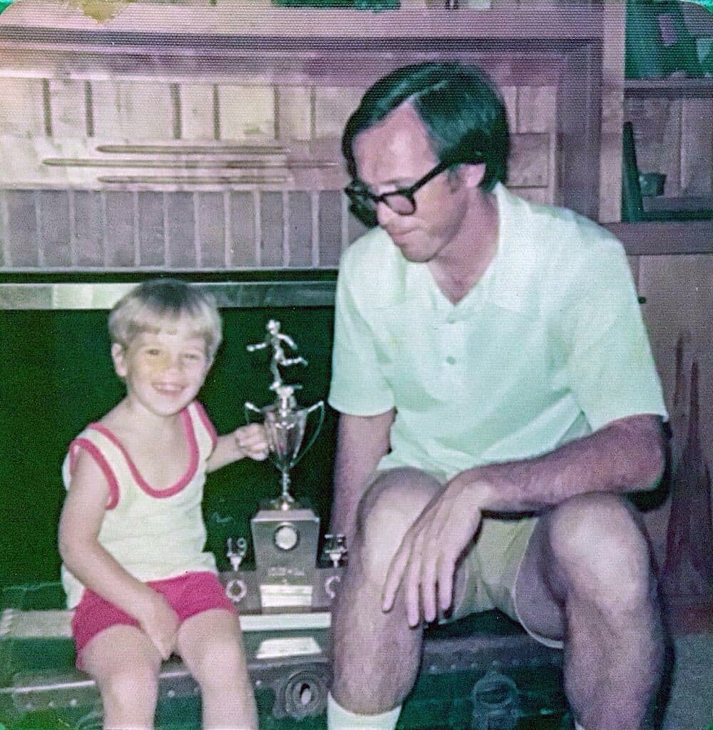 Me and my father with one of the trophies from the girls track team he coached in 1975